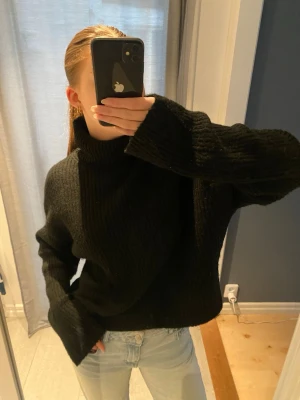 Svart stickad polotröja  - Mysig svart stickad polotröja från H&M med breda ärmar och hög krage. 