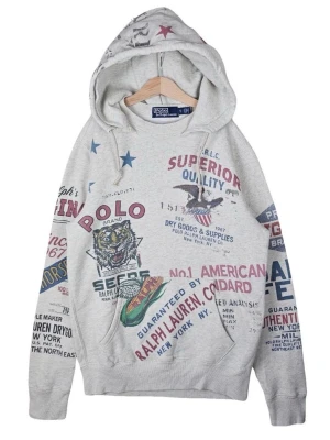 FW19 Polo Ralph Lauren ”Dry Goods” AOP Hoodie - Säsongmodell från märkets handelsarv. Grå hoodie med känguruficka. Den har vattenbaserade AOP tryck på framsidan, baksidan och huvan.                                 Jag lämnar in för leverans samma dag. (Vid undantag senast dagen efter.).                                                (Hoodien finns inte i Sverige.)                                             Mått:46cm x 63/65cm.                                         SÄLLSYNT OCH AUTENTISK. INTE ANVÄND.