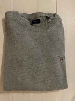 GANT Tröja - Jag säljer en snygg grå stickad tröja från GANT.🙌Skicket är fint. Använt skick. Storleken är 158/164, men passar för xs också! Hör av dig vid några som helst funderingar eller frågor!🙌💪