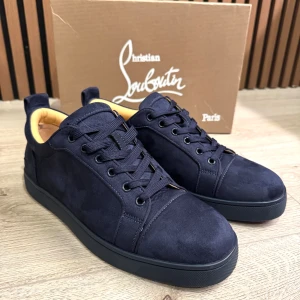 Mörkblå sneakers från Louboutin - Snygga mörkblåa sneakers från Louboutin, med en röd sula. Skorna är endast använda 1 gång.priset är ej fastställt. Tveka inte att höra av er! Pruta kan göras.