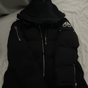 Moose Knuckles vinterjacka  - Säljer en svart snygg Moose knuckles 100% äkta. Ingår svart päls. Jackans dragkedja är sönder men det går och fixa enkelt om man går till en sån affär där de fixar sånt. Denna håller upp värmen till 20 till 30 minusgrader. Det finns knappar man kan sätta ihop i jackan. Man han t.ex använda de för att dragkedjan e paj. Skriv om intresse! Det ingår svart päls
