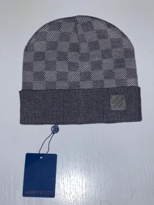 Fet mössa  - Säljer en snygg grå mössa med schack mönster. Mössan är även i nytt skick.