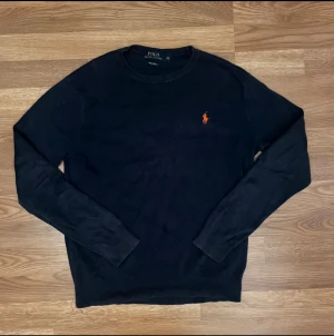 Mörkblå tröja från Polo Ralph Lauren XS - Svart långärmad tröja från Polo Ralph Lauren i mjuk pima bomull. Klassisk rund hals och  broderad logga på bröstet. Enkel och stilren design som funkar till jeans. Perfekt för dig som gillar tidlös stil.