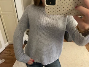 Ljusblå stickad tröja  - Mysig ljusblå stickad tröja med rund hals och långa ärmar. Tröjan har en enkel och clean look, perfekt att slänga på sig till jeans. Den är loose i passformen och har ribbade muddar vid ärmslut och nedtill 