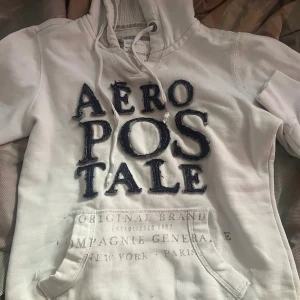 Vit Aéropostale Hoodie - En snygg Vit hoodie från Aeropostale med blått tryck (ser typ ut som jeans material). Säljer då är mindre i storlek. Det  är egentligen storlek M men passar som S/XS. Priset är förhandlingsbart! 💗