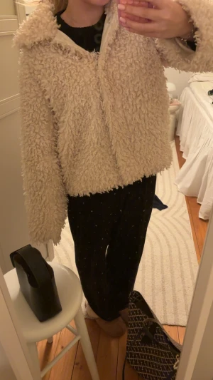 Beige teddyjacka med fluffig look - Säljer en supermysig beige teddyjacka med fluffig och krullig yta. Jackan har en loose passform och långa ärmar, perfekt för dig som gillar en chill och trendig stil. Passar dig som vill ha en varm jacka med cool vibe.