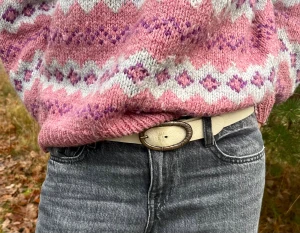 Vit bälte - Ett snyggt vit bälte med små blom detaljer! Det har sina skavanker och lite missfärgningar… dock något bältet väger upp! Bältet är ca 90cm långt!