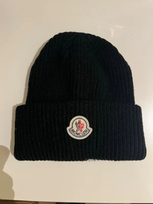 Moncler mössa - En svart Moncler mössa,perfekt nu under vintern. 