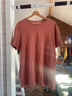 Korallfärgad t-shirt från Dressmann  - Enkel och snygg korallfärgad/orange t-shirt från Dressmann i storlek XL. T-shirten har rund halsringning och korta ärmar. Tillverkad i mjuk bomull.