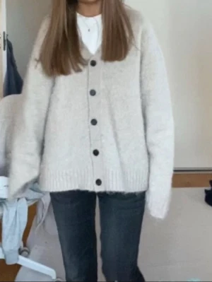 Beige oversized kofta med knappar - Mysig beige oversized kofta med  svarta knappar framtill. Koftan är stickad och har långa ärmar samt ribbade muddar vid ärmslut och nederkant💓💓