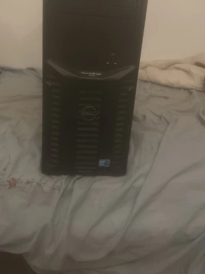 Dell PowerEdge T110 - Dell PowerEdge T110 server med Intel Xeon-processor. Robust och pålitlig stationär dator, perfekt för småföretag eller hemmabruk. Frontpanelen ser hel ut, inga synliga större skador eller repor. Klassisk svart design.