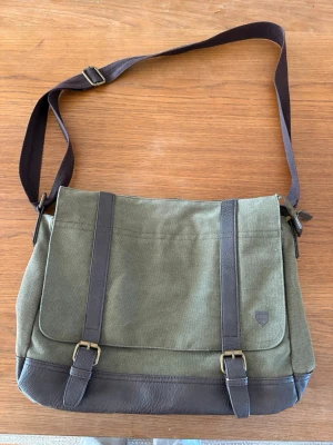 Väska  - Säljer denna coola väska med ett lite äldre stuk till sig. Den har mycket utrymme med många fack. Väskan är i ett bra skick