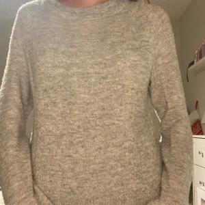 Ljusgrå stickad tröja - Mysig ljusgrå stickad tröja med rund hals och långa ärmar. Perfekt för kyliga dagar och enkel att matcha med olika outfits. Tröjan är från vero Moda 🥰