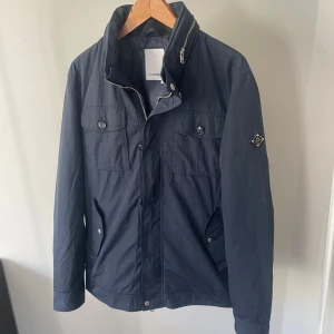 J.Lindeberg Fieldjacket  - Jättefin jacka ifrån J.Lindeberg i storlek large men passar även medium, jättebra skick ser ut som ny, inga defekter. Har en inbyggd luva som går att väckla ut. Hör gärna av dig om du har några frågor!