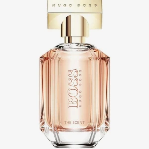 Hugo Boss The Scent parfym - Hugo Boss The Scent är en elegant parfym i en lyxig, åttakantig glasflaska med guldigt metallock. Flaskan är transparent och visar den ljusrosa doften inuti. Märket och doftnamnet är ingraverat på framsidan. Perfekt för dig som gillar stilrena och exklusiva parfymer. Se bilderna hur mycket det är kvar i Parfymen. 🌸💞Fint skick! Nypris: 620 kr!!