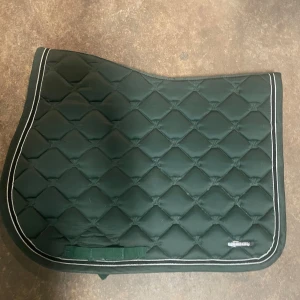 Mörkgrönt lami-cell schabrak - Ett väldigt snyggt och elegant grönt schabrak från Lami-Cell i storlek FULL med snygg svart-vit kant. Väldigt bra passform till manken💕 Nypris 790