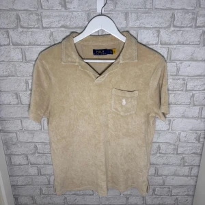 Ralph Lauren frotté piké  - Beige frotté piké ifrån Ralph Lauren i bra skick. Använd sparsamt och sitter perfekt. En väldigt unik och populär piké som nu söker ny ägare! Hör av dig vid intresse 🙌