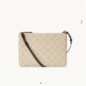 Beige axelväska från By Malene Birger - Stilren beige axelväska med rutigt mönster och justerbar mörkbrun axelrem. Väskan har guldfärgad dragkedja och är tillverkad i tålig syntet. Använd ett fåtal gånger och ser ut som ny! skriv för fler bilder