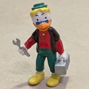 Disney samlarfigur, 1984 - Disney leksaksfigur av en anka med verktygslåda och skiftnyckel. Disney figuren kan användas som dekoration. Disney figuren är av plast 