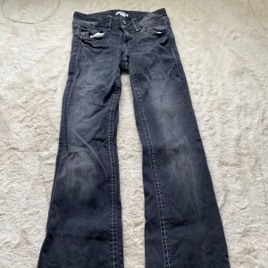 Mörkgrå bootcut jeans - Snygga mörkgrå jeans med bootcut passform och klassiska fickor både fram och bak. Jeansen har tydliga kontrastsömmar och en lätt tvättad look. Perfekta för dig som gillar en avslappnad men ändå trendig stil.