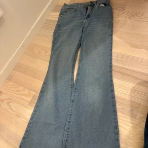Ljusblå bootcut jeans - Säljer ett par ljusblå jeans med bootcut-modell. Jeansen har klassisk femficksdesign och är tillverkade i mjukt denimtyg. Perfekta för dig som gillar en retroinspirerad look med utsvängda ben.