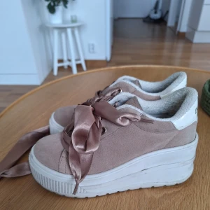 Platåsneakers med satinband stl 37 - Snygga sneakers i beige/rosa mocka med bred vit platåsula och lyxiga satinband som snörning. Insidan är fodrad med mjukt material för extra komfort. Rund tå och stilren design som sticker ut med de breda, glansiga banden.