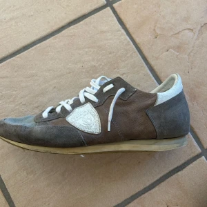 Grå sneakers från Philippe Model - Jätte sköna Phillips model som passar runt 41-42 och e riktigt snygga till sommaren, kan sänka pris vid snabb affär. de är lite tradiga vid framsidan av skorna men det är inget hål utan bara tyget. Box kommer med