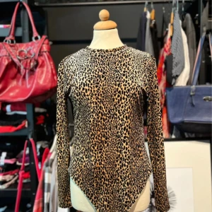 Leopardmönstrad body från H&M Divided - Säljer en leopardmönstrad body från H&M Divided med lång ärm och rund hals. Bodyn har en djup öppen rygg och knäppning i grenen.  🐆 Storlek: M/L 🐆 Skick: Mycket bra 🐆 Snyggt att styla med jeans, kjol eller under en kavaj 🐆 Pris kan diskuteras!  Tveka inte att skriva vid frågor eller funderingar💌