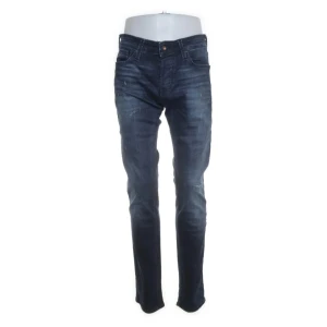 Mörkblå slim fit jeans från Jack & Jones - Snygga mörkblå jeans från Jack & Jones med slim  passform och klassisk femficksdesign. Jeansen har lätt slitna detaljer och är tillverkade i stretchig denim för extra komfort. Perfekta för dig som gillar en modern och tight look.