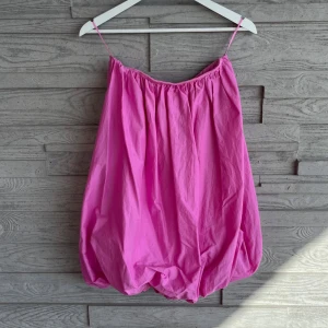 Rosa ballongklänning med tunna axelband - Säljer en rosa ballongklänning från Zara i storlek S. Klänningen har inga axelband. Materialet är bomull och klänningen är kort. Klänningen är oanvänd. 