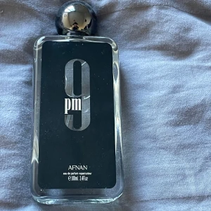 Afnan 9pm Eau de Parfum 100ml - Afnan 9pm Eau de Parfum, 100ml. Modern och stilren parfym med cool design, perfekt för dig som vill sticka ut. Flaskan och förpackningen har en snygg svart look med tydlig logga. Inga ingredienser eller tillverkningsland syns på bilderna.