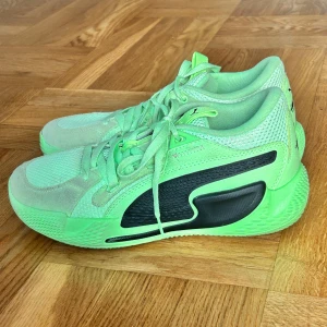 Puma sneakers i neonlime och svart - Säljer ett par riktigt snygga Puma sneakers i neonlimegrönt med svarta detaljer. Skorna har mesh och mocka på ovandelen, cool logga bak och snörning framtill. Perfekta för dig som vill sticka ut med färg och sportig vibe. Bara använda inomhus 
