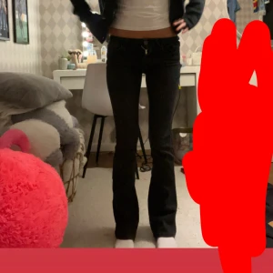 Svarta bootcut jeans från ONLY XS - Svarta jeans från ONLY i modellen bootcut med låg midja. Snygg passform som sitter tight upptill och släpper ut vid bensluten. Klassisk femficksdesign och stretchigt material för extra komfort. Perfekta för dig som gillar en stilren och enkel look.