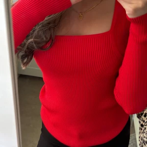 Röd ribbad långärmad topp från Mango - Säljer en snygg röd ribbad topp från MANGO med fyrkantig halsringning och långa ärmar. Materialet är mjukt och stretchigt, perfekt för dig som gillar en stilren look med lite edge. Passformen är normal och toppen är enkel att matcha med både jeans och kjol.