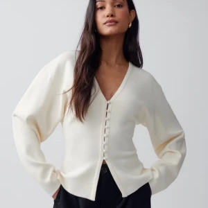 Beige kofta med knappar från Gina Tricot - Superfin beige kofta från Gina Tricot med v-ringning och klädda knappar framtill. Långärmad och i mjukt stickat material. Det är en fläck på vänster arm som jag inte fick bort i tvätten, har dock inte försökt med fläckborttagning så det kan funka att få bort den med det. Det är endast använd några gånger men pga fläcken sänker jag priset, hör av er vid frågor och pris kan diskuteras!💕🩵