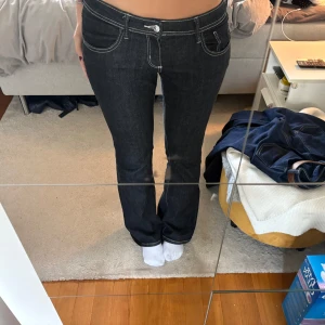 Mörkblå bootcut jeans med kontrastsömmar gina tricot lowwaist - Snygga mörkblå jeans med bootcut-modell och tydliga vita kontrastsömmar. Klassisk femficksdesign och normalhög midja. Jeansen har en stilren look och är tillverkade i ett robust denimtyg som sitter riktigt bra.