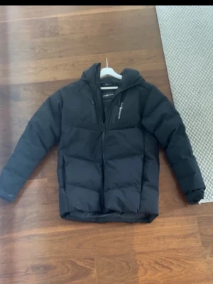 Sail Racing vinterjacka  - Sail Racing vinterjacka – svart, stl 176 Snygg och varm pufferjacka med huva från Sail Racing. Bra skick, inga hål eller fläckar. Perfekt nu till vinter/vår. Nypris högre, säljer billigt för snabb affär. Skickas snabbt 📦 skriv vid minsta fråga!!!