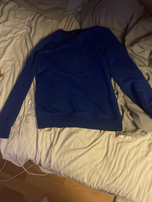 Blå Stone Island sweatshirt M - Säljer en blå sweatshirt från Stone Island i storlek M. Tröjan har det klassiska Stone Island-märket på ärmen och ett diskret emblem på bröstet. Långärmad modell med ribbade muddar och rund hals. Perfekt för dig som gillar streetwear och snygga detaljer.
