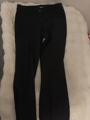 Svarta kostymbyxor från Bik Bok - Snygga svarta kostymbyxor från Bik Bok med klassisk rak passform och pressveck. Byxorna har hällor för bälte och sidofickor. Perfekta till en stilren look och passar till många olika outfits.