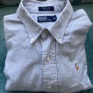 Ralph Lauren skjorta  - randig skjorta från Ralph Lauren i blått o vitt. Skjortan sitter som en S-M och passar perfekt både som en vanlig skjorta och med en vit t-shirt under. Pris kan alltid diskuteras!!