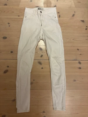 Vita skinny jeans - Gina Tricot Molly - Säljer ett par vita skinny jeans från Molly i storlek S. Byxorna har hög midja och dragkedja med knapp framtill. Materialet är mjukt och stretchigt, perfekt för en clean och fräsch look.