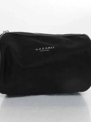 Svart necessär från Azzaro Parfums - Snygg svart necessär från Azzaro Parfums i cylinderformad design. Väskan har dragkedja upptill och detaljer i svart konstläder med präglat mönster på sidorna. Perfekt för att organisera dina produkter när du är på språng.