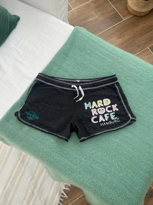 Hard rock café lågmidjade shorts  - Ett par shorts från Hard Rock Café i storlek M. Mått på bilder. Något noppriga, därav pris. Jag fraktar inom 24h, PostNord prioriteras. Se liknande plagg i min profil!