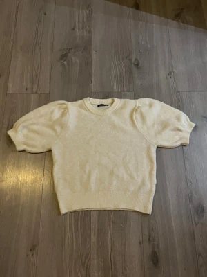 Vit stickad tröja med puffärm - Superfin vit stickad tröja med korta puffärmar och rund hals. 