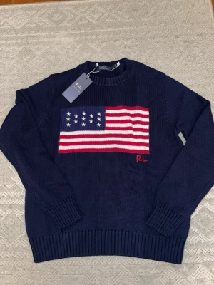 Marinblå Polo Ralph Lauren Med USA/ Amerikansk Flagga - Säljer denna marinblåa tröja med USA / Amerikanska Flaggan. Den är storlek S.