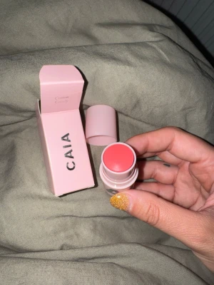 CAIA Rouge Stick Cotton Candy - Superfin rouge i stickformat från CAIA i färgen Cotton Candy. Kommer i en söt ljusrosa förpackning med matchande kartong. Krämig formula som är lätt att blenda ut och ger kinderna en fräsch rosa ton. 