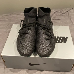 Nike Phantom Luna II Elite FG Svarta storlek 42,5 - Nike Phantom Luna II Elite FG, använd kanske 3-4 träningar jätte sköna och man får med påsen som tillhör skorna, ordinarie pris 3499kr 