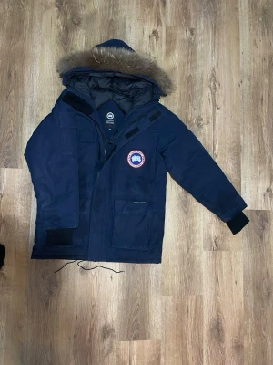 Äkta Canada Goose - Parkajacka från Canada Goose i mörkblå färg med ikonisk patch på bröstet. Äkta kom med bud eller byten om ni vill 