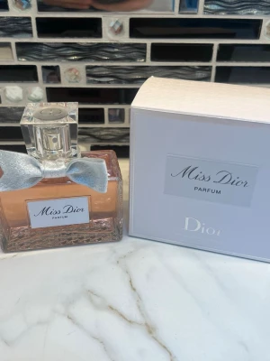 Miss Dior Parfum 80ml - Miss Dior Parfum från Dior i elegant flaska med silverfärgad rosett och sopren design. Perfekt för dig som vill ha en ikonisk och lyxig parfym på hyllan. Kommer med originalask.