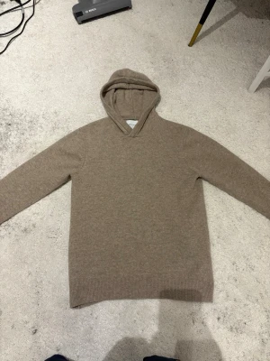 Kashmir hoodie beige  - Helt ny Kashmir tröja, köptes i sommras och har använts 3-4 gånger men är dessvärre för liten i storlek för mig. Nyskick inga skador. Köpt för 800 kr från carlings. 